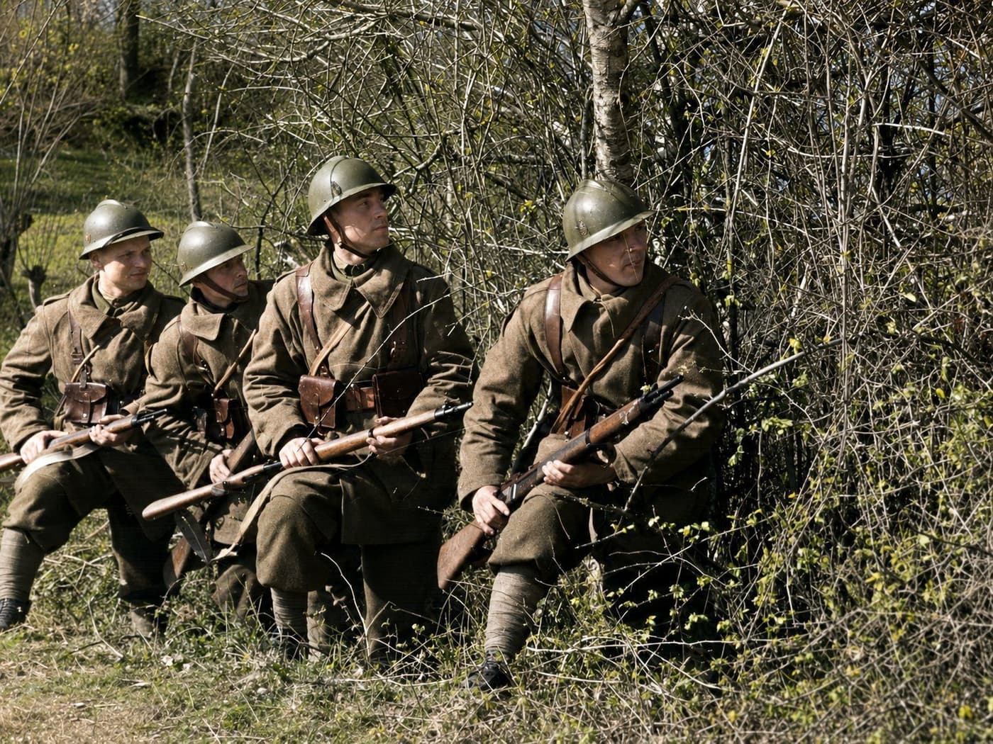 Polish infantry soldiers in steel helmets keep watch from cover along the frontier, rifles ready, September 1939. Colourised period photograph.